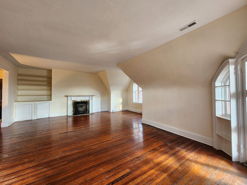Giant great room with built-in shelves, fireplace, lots of windows and beautiful wood floor.