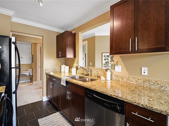 Open concept kitchen with cutout for viewing tv or entertaining guests in the living room