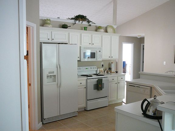 Kitchen w/white cabinets,lots of counter space and ceramic tile floors