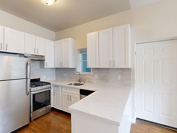 Modern kitchen with cabinetry, stainless steel appliances, and marble countertops. Hardwood floors add warmth. Bright and clean atmosphere.