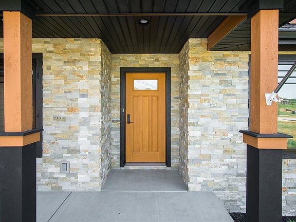 Custom Diamond Kote Premium Collection siding accented by Sunset Gold dry-stacked stone.
