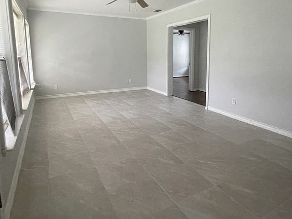 living room off hallway leading to bedrooms and bathrooms