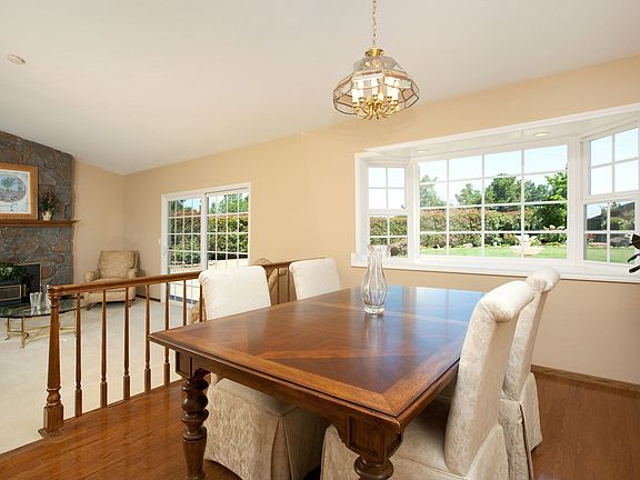 Formal dining room with large windows, filled with natural light
