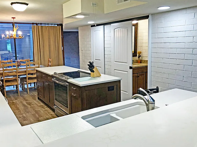 The island has a large GE convection next to a cabinet with cookware and slideout shelves. A half bath and closet is off the hallway.