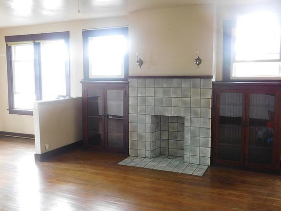 Living room (13" x 18.5") with built-ins, decorative fireplace and hardwood floors.