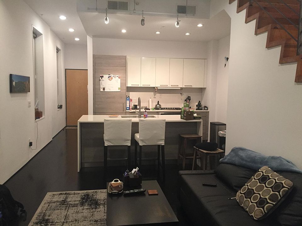 View downstairs from back of unit towards entryway, kitchen, and living area