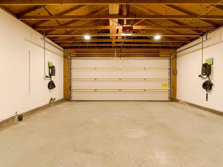 The garage is equipped with dual Level 2 EV chargers, allowing for fast and efficient charging of electric vehicles. Spacious and well-organized, it accommodates two cars and provides the convenience of simultaneous charging for eco-friendly driving.