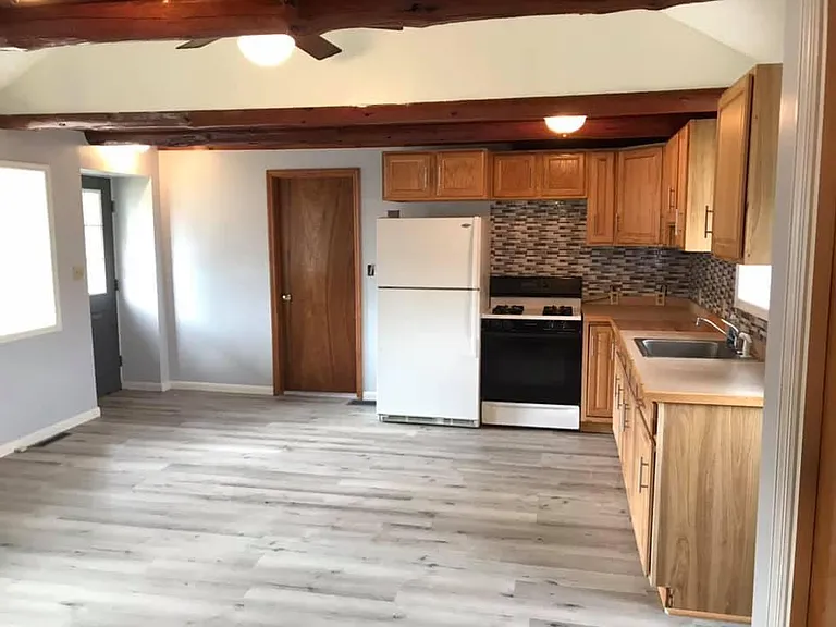 Kitchen area looking towards larger bedroom.