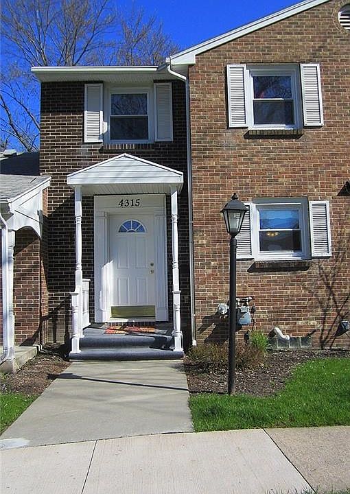 The definition of "Townhome" - elegant brick faade and welcoming covered front porch.  When the landscaping starts blooming, it will complete the look!