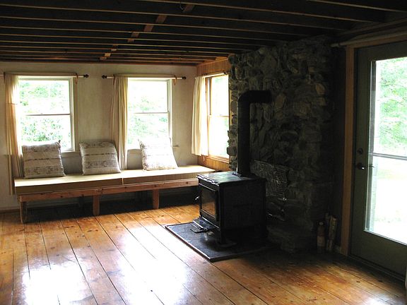 Living room #1 w/ wood stove and beam ceiling
