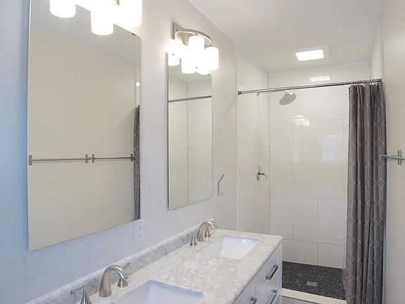 Marble bath vanity, with 2 sinks and a large walk-in shower. (there's a bathtub in the secondary bathroom). There's extrax storage under the sinks, including drawers and shelves.