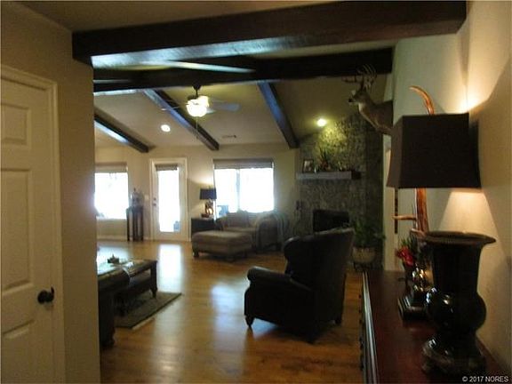 Large Great Room with corner stacked stone fireplace and hardwood floors.  Opens onto covered patio overlooks private backyard.