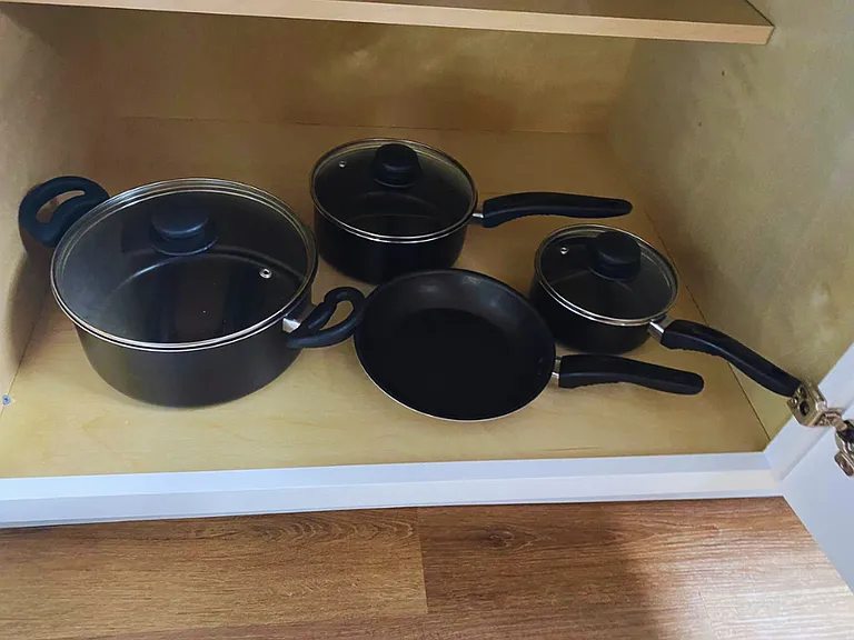 Pots with lids and pans available for your cooking needs.