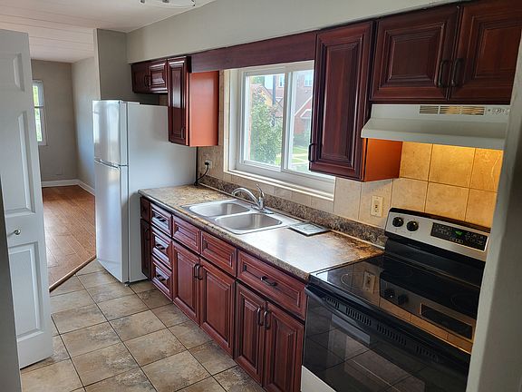 Cherrywood cabinets,stainless steel stove, Large window above sink.