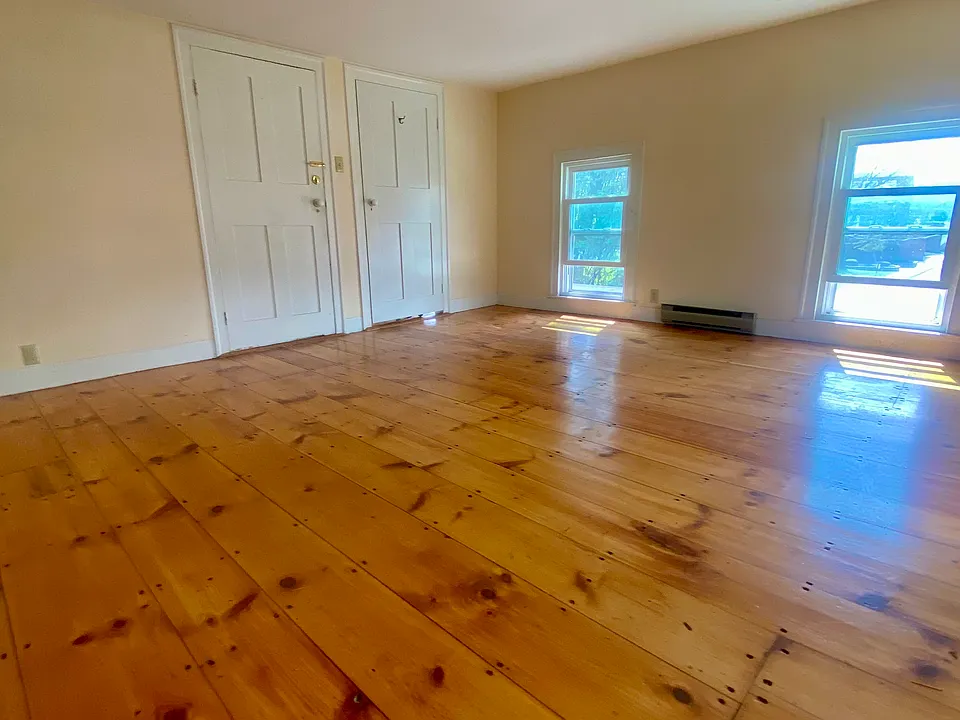 Living room with front door and door to small side room.