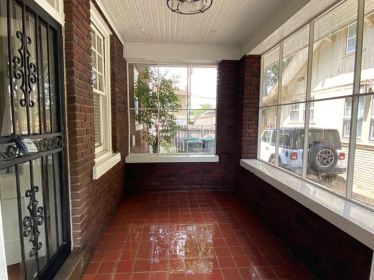 Covered, screened brick porch with ceiling fan.