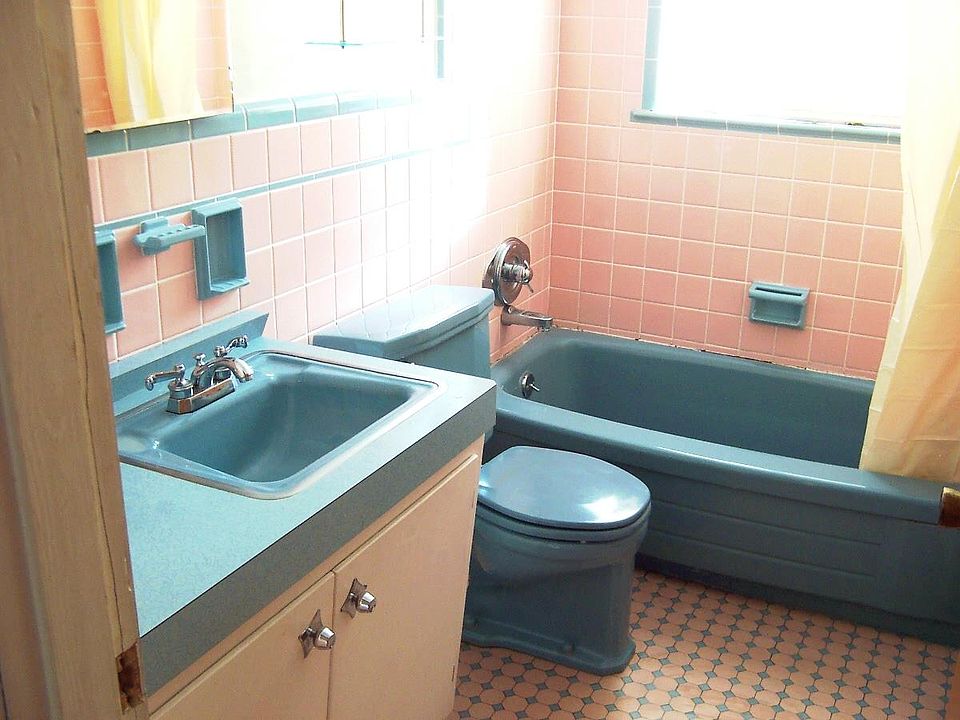 Full ceramic tile bath in its original period colors ('57 Cadillac pink and 2-seater Thunderbird blue). Original "boomerangs" design Formica counter top.