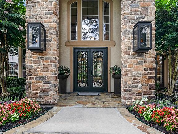 Breathtaking stacked stone and stucco entry with coach gas lanterns on each side, set the tone for what you are about to enjoy once you enter the home.