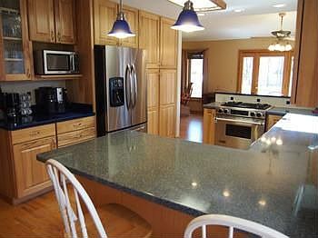 Beautiful hickory cabinets with plenty of extras!  Not pictured is the walk-in pantry space. Solid surface counters and an open view of the dining area and yard.