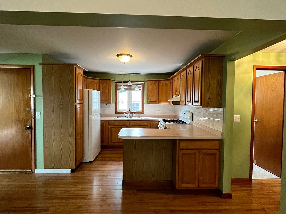 Standing in dining area looking toward kitchen. Entrance is door on the left. Bathroom is door on the right.