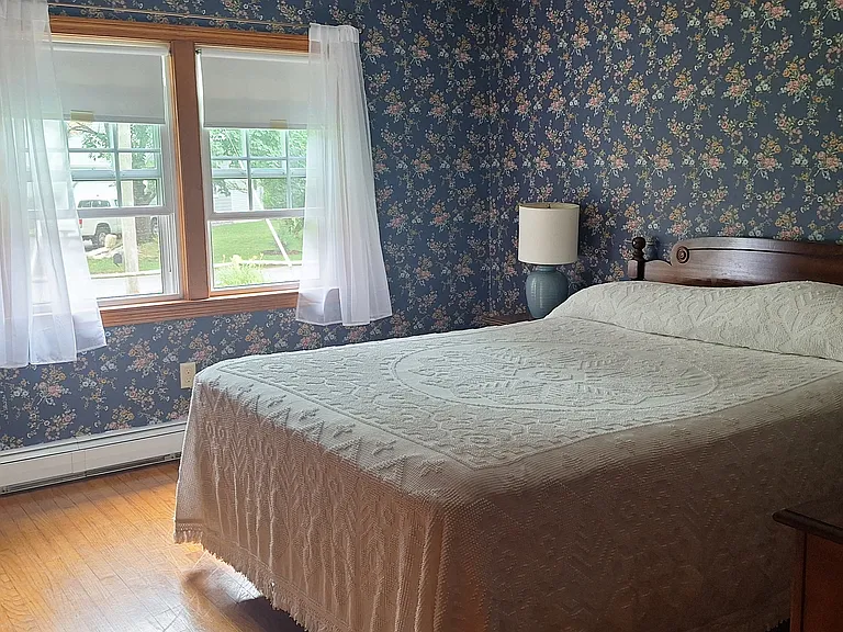 Master bedroom shared bath with shower leads into second front bedroom with twin beds.
