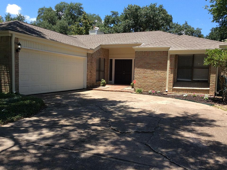 Front entrance with double door, two car garage and driveway.