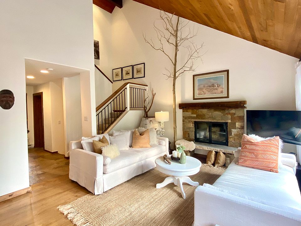 Living Room with the fireplace and the stairs to the Primary bedroom with vaulted ceilings.