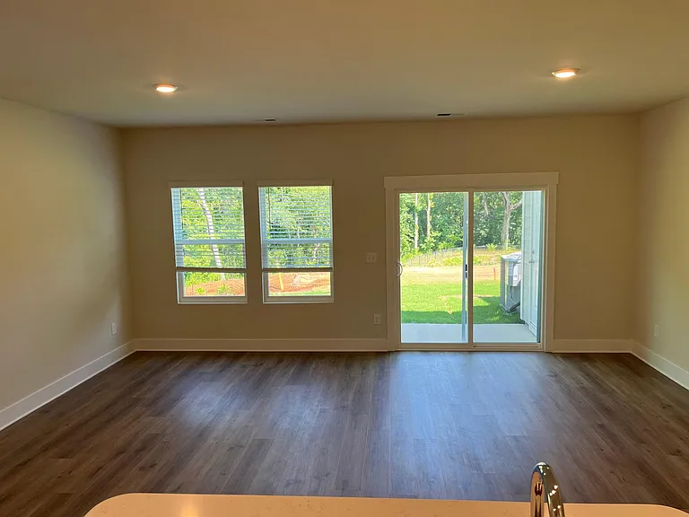 view from kitchen on one side of island counter towards dining/living space and backyard