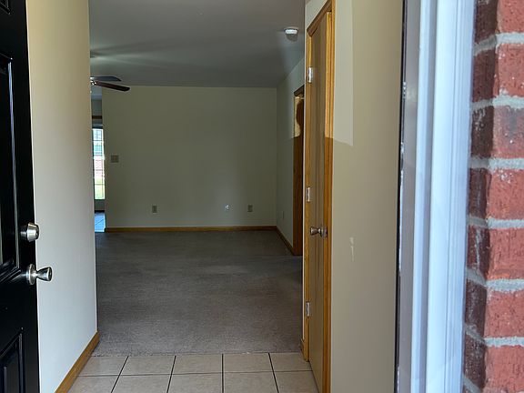 Entryway with coat closet and partial view of living room