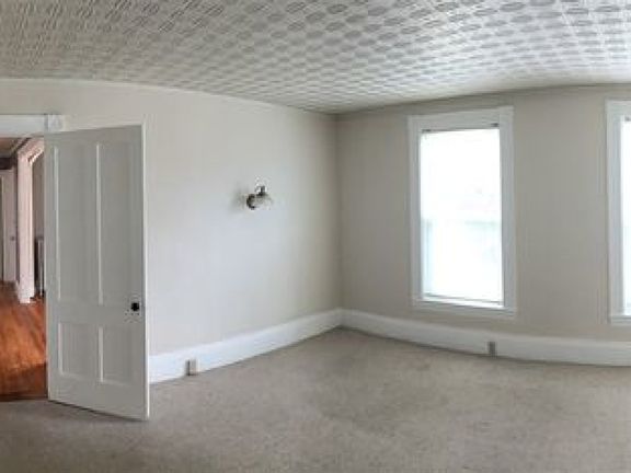Bedroom offers a charming original built-in glass-front cabinet with doors and ample closet space.