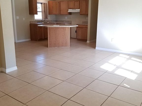 Standing front door looking through living room area into kitchen. Hallway to the right for bedrooms 2 & 3 and bathroom