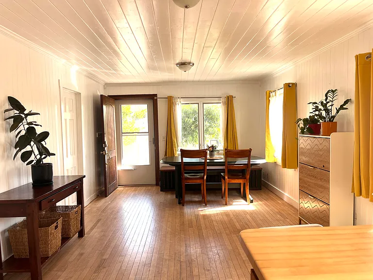 Looking into the living room from the kitchen. Front yard and door view.