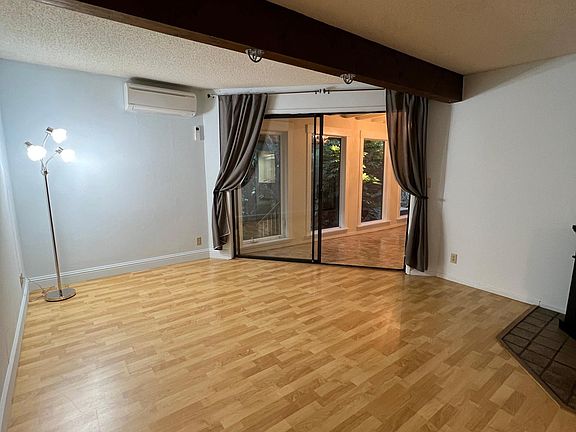 Electric fireplace to right and heating and air unit on upper wall