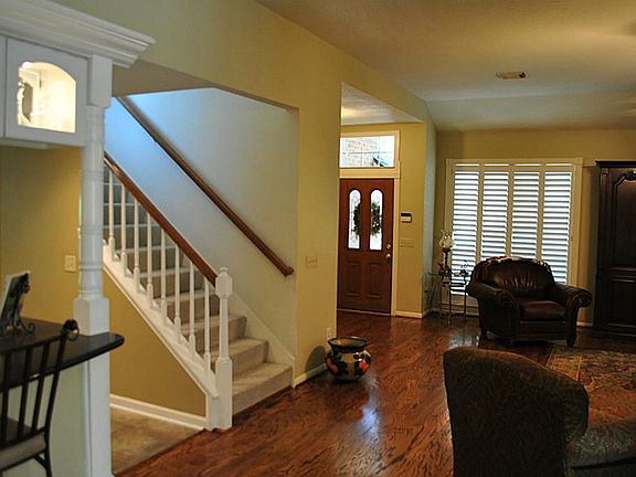 View of front door, kitchen bar and stairs leading to the game room upstairs