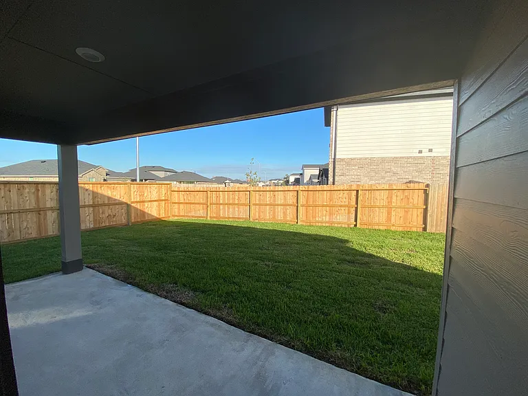 View of part of the patio space and backyard from the back door