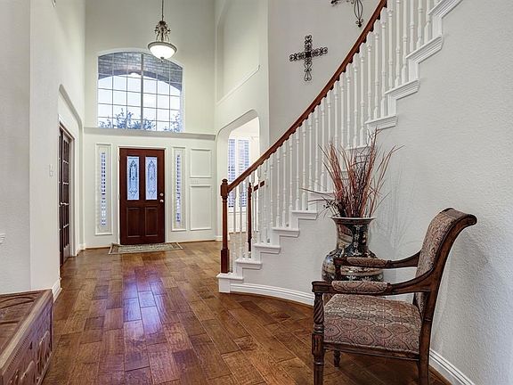 From this view you can see the custom craftsmanship of this house, from the sweeping staircase and alcove to the cut outs in the wall and framework around the door.