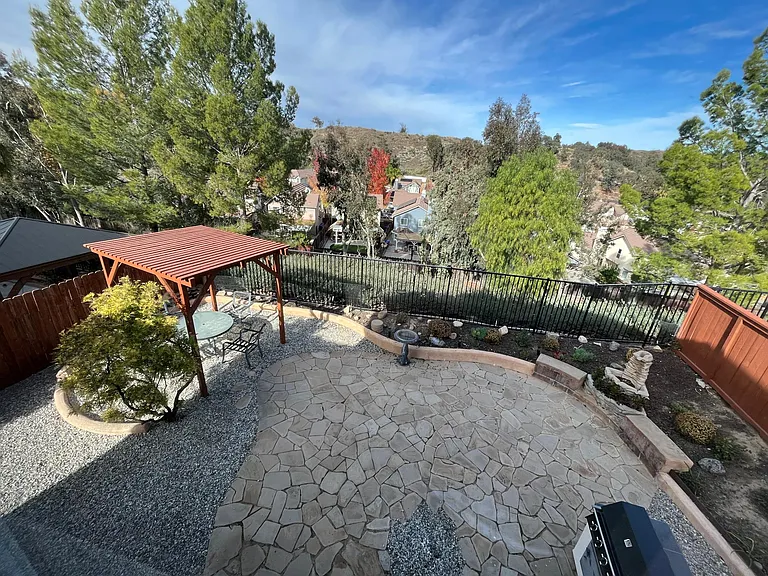 Large, fully landscaped rear yard with pergola, gas BBQ, and stunning views.