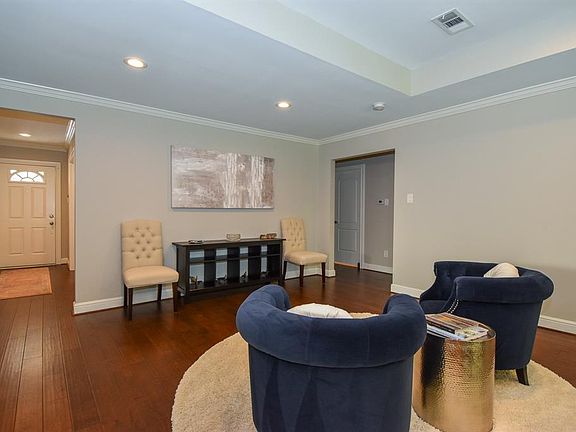 Tray ceiling, recessed lighting, crown molding and rich wood floors accent the sitting area.