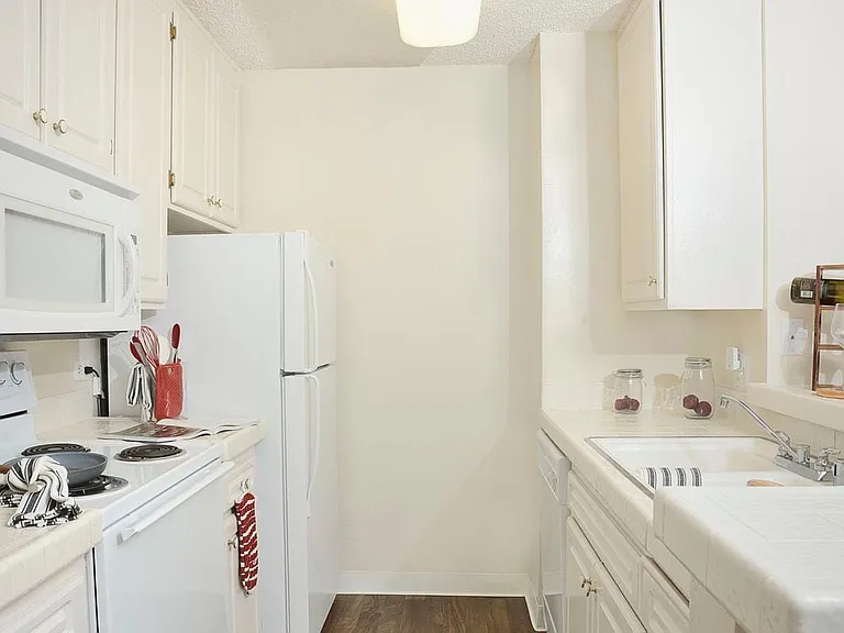 Classic Package I kitchen with white appliances, white tile countertops, white appliances, and vinyl tile flooring