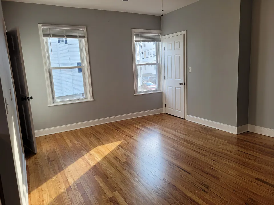 Dining area with galley kitchen and entry door on left, bathroom door in middle.