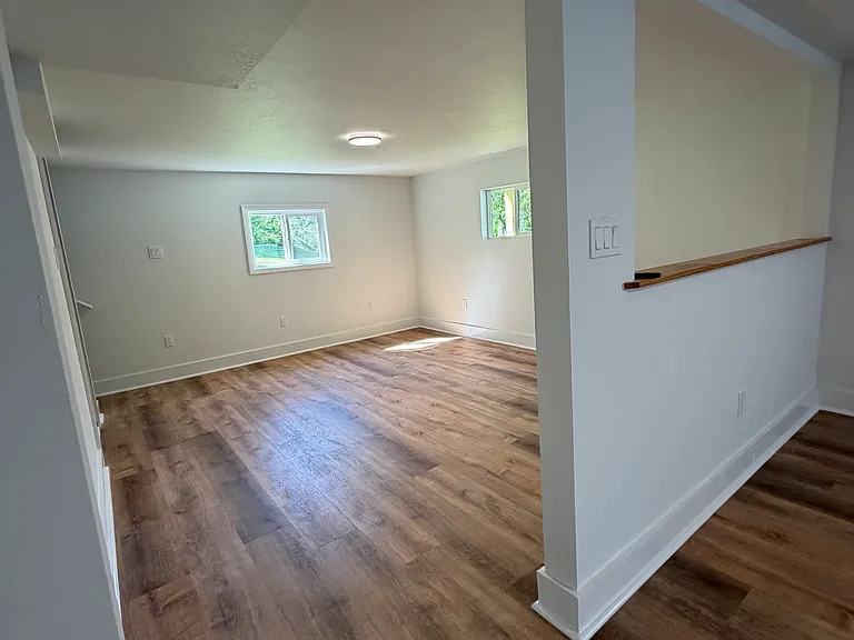 Living room which has stairs that lead upstairs to the 3 bedrooms and bathroom. There is laundry and storage down here as well