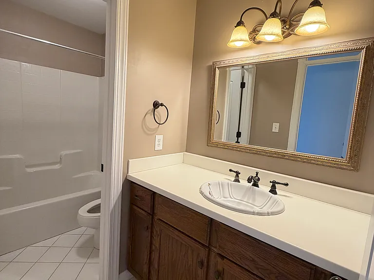 Clean, well-lit full bath paired with the guest bedroom, featuring a tub-shower combo, fresh tile and plenty of counter space for toiletries.