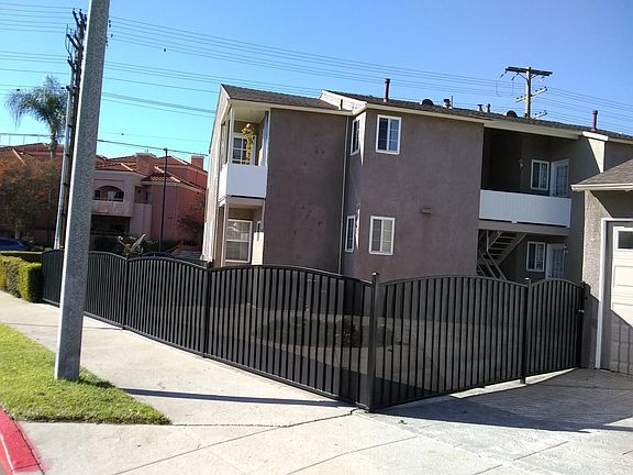 Back of Apartment building showing fenced in backyard.