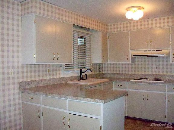 Kitchen with new appliances, counters, sink and faucet.