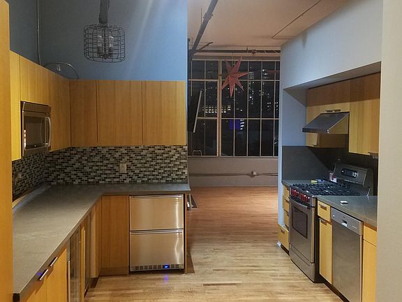 Entry into the unit. Spacious kitchen with stove and hood, dishwasher, full-sized fridge, beverage fridge, wine fridge, under counter freezers, & built-in microwave oven.