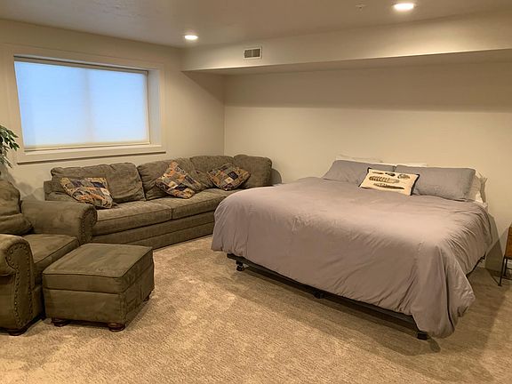 Downstairs bedroom with couch and chair.