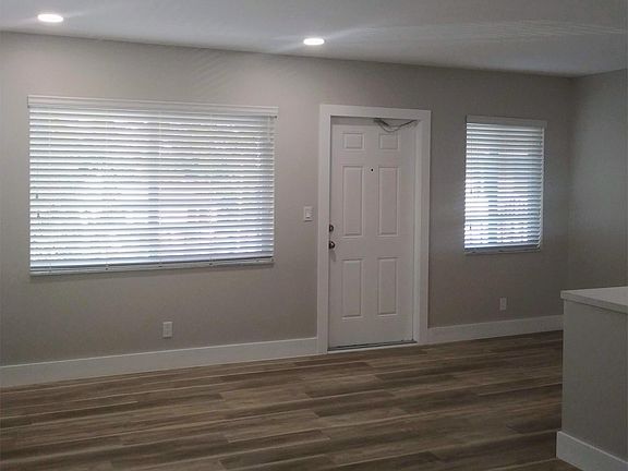 sunny great room and dining area with views of swimming pool, palm trees and Holly Heights Drive!