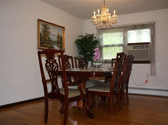 FORMAL DINING ROOM W/ HARDWOOD FLOOR, CHANDELIER,& A/C WINDOW UNIT