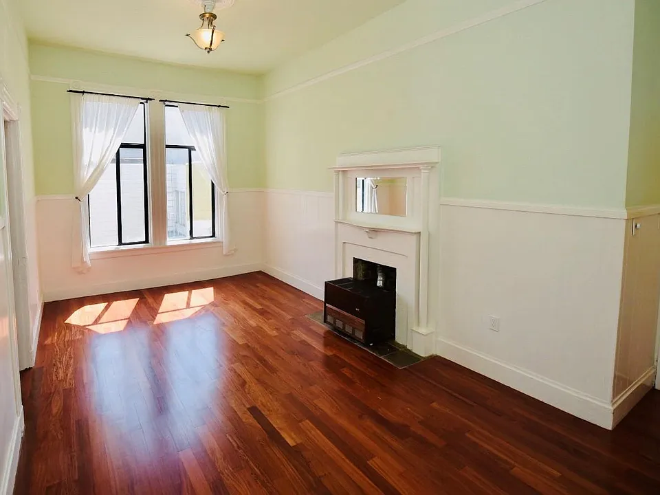 Living room area. Apartment entrance is to the right in this picture. Flooring has just been resurfaced and re-stained. They turned out beautiful. The gas furnace located by the fireplace heats the entire apartment in a matter of minutes. Very sunny