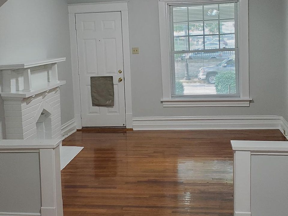 View of the front two rooms looking toward the front door. Original hardwood floors, new ceiling fans, beautiful connecting archway.